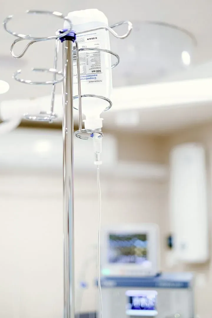 Sterile hospital IV drip setup with medical equipment in the background at a Koh Samui clinic