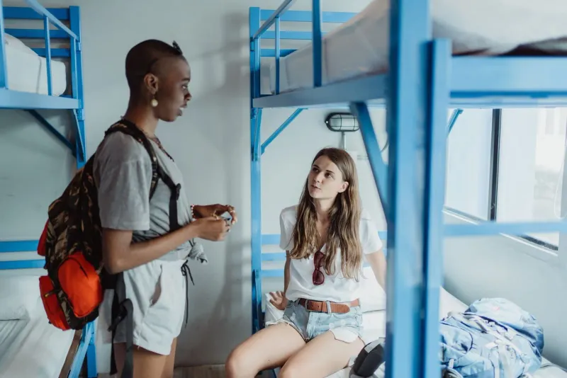 Two travelers in a Koh Samui hostel dormitory representing the island's budget accommodation scene