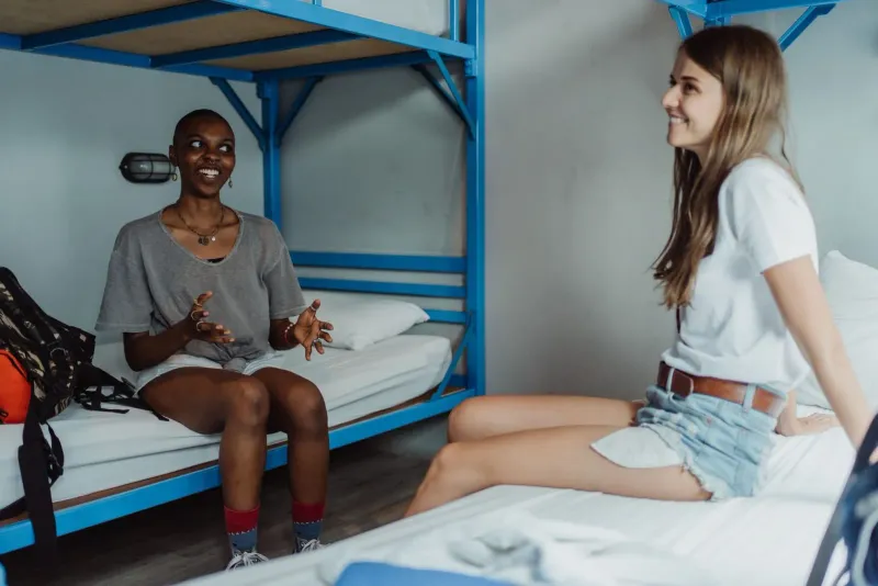 Travelers sharing a conversation on a bunk bed in a Koh Samui backpacker accommodation