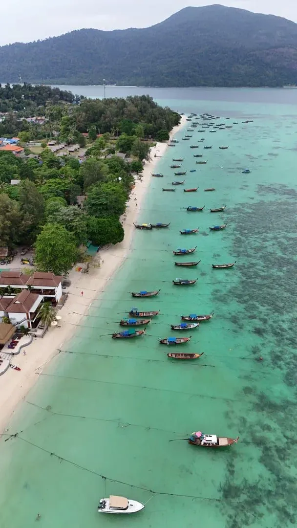 Traditional longtail boats lined up on a turquoise beach typical of Koh Samui's quieter coasts