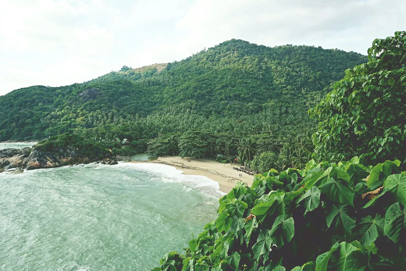 Scenic tropical beach on Koh Phangan surrounded by lush green hills, the first island stop on the 10-day itinerary