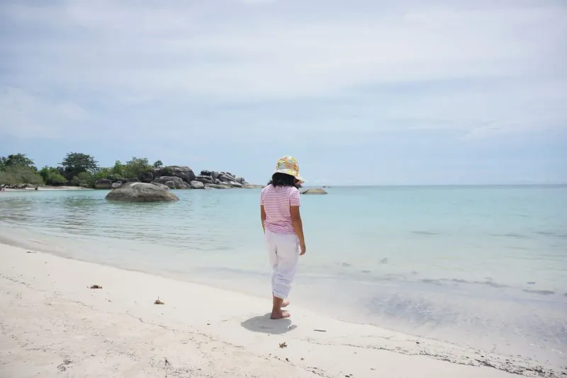 Woman on a quiet tropical beach representing Koh Samui's relaxed family pace