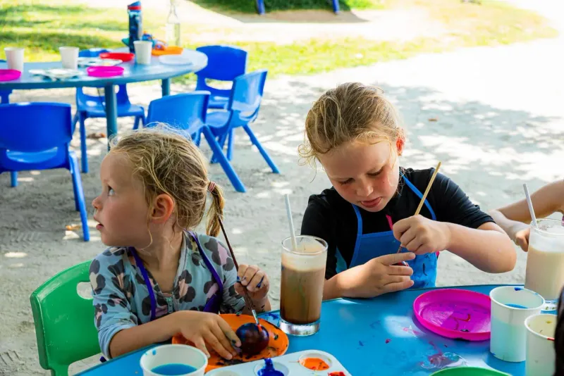 Kids doing outdoor crafts at a picnic table, a rainy-day style activity in Koh Samui