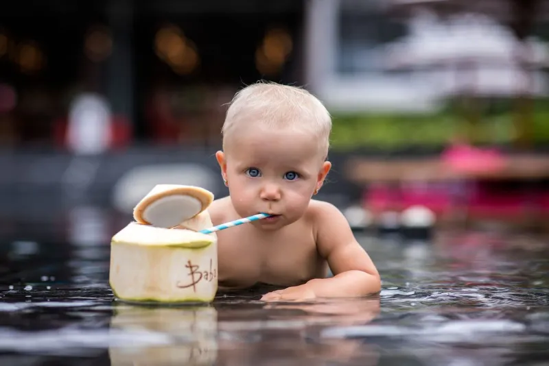 Baby drinking coconut water poolside, a toddler-friendly Koh Samui activity