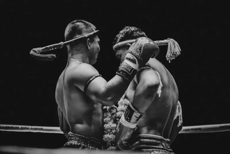 Black and white shot of two Muay Thai fighters exchanging strikes in the ring