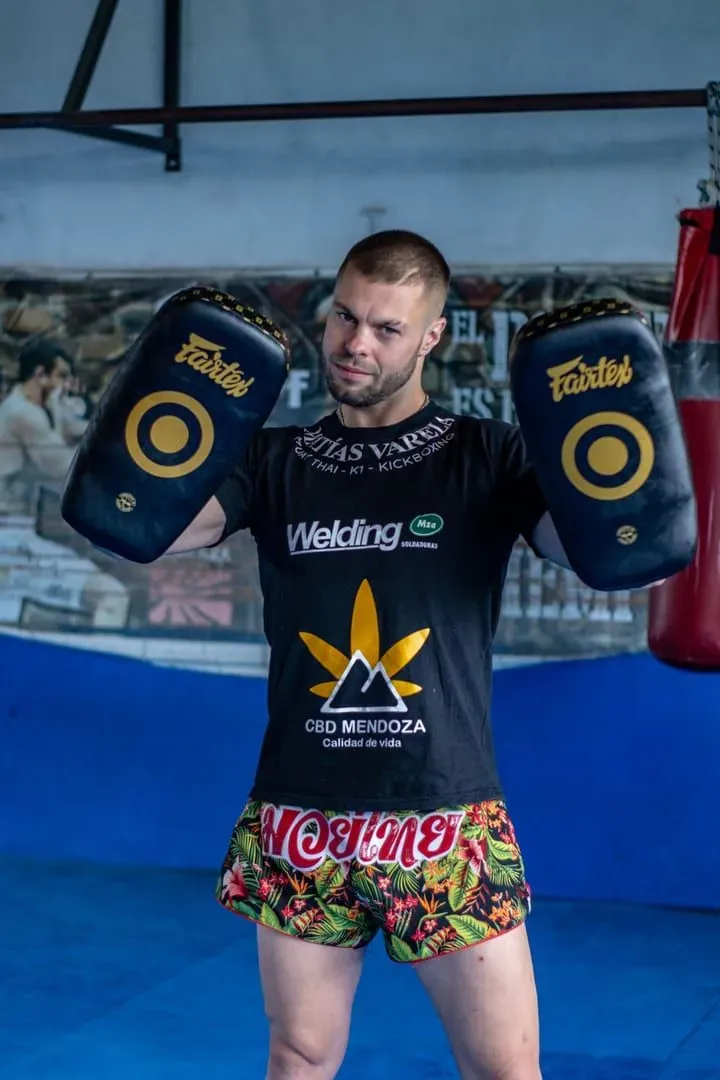 Trainer holding punch mitts during a boxing drill, the pad-holding style used across Yodyut Muaythai's sessions