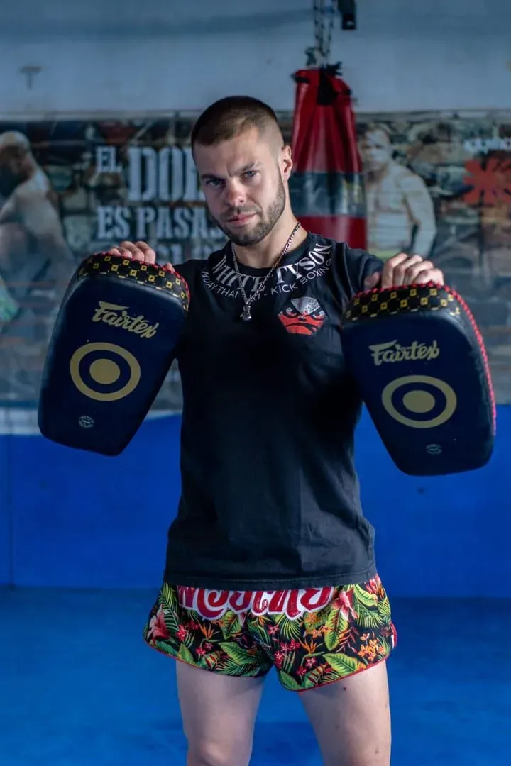 Trainer holding focus pads for a muay thai student at a Koh Samui gym