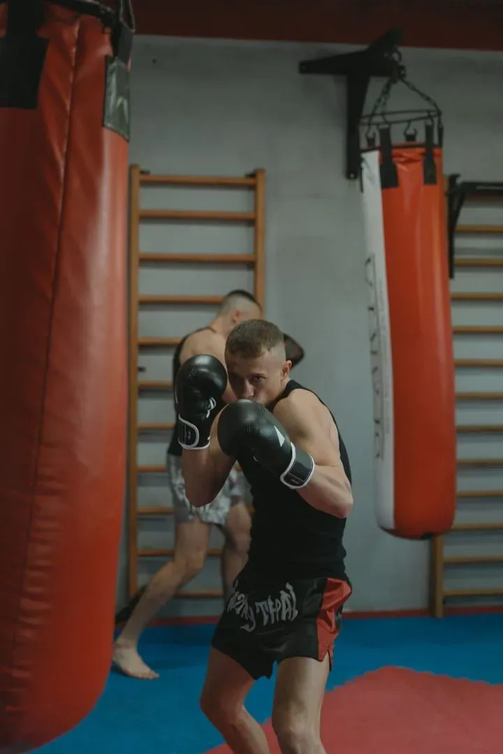 Two trainees practicing muay thai punching bag drills in Koh Samui