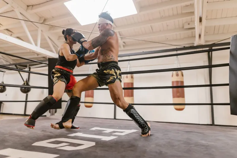 Man and woman sparring together in a mixed-gender muay thai class