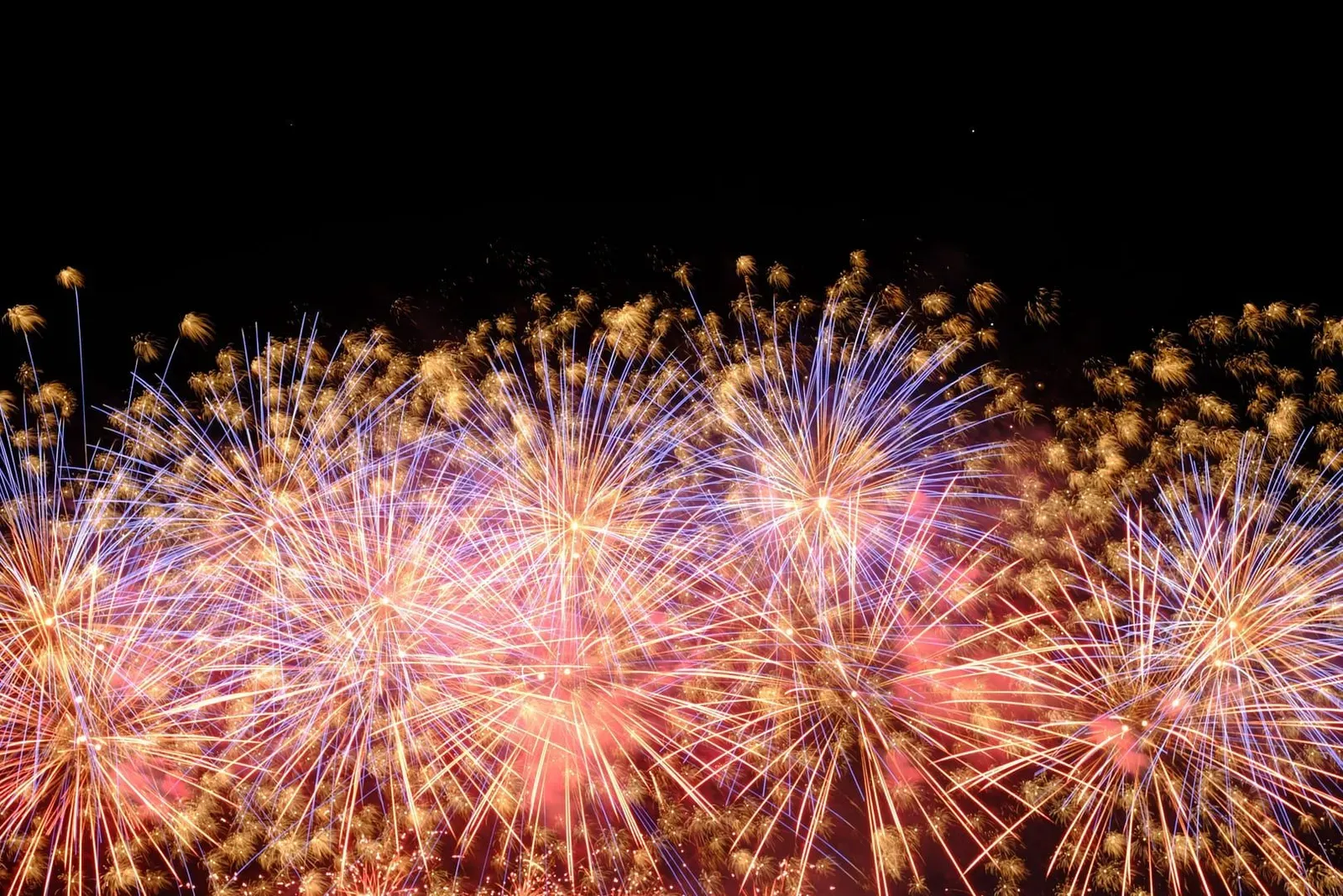 Vibrant fireworks bursting over the night sky during a New Year's Eve countdown celebration on Koh Samui