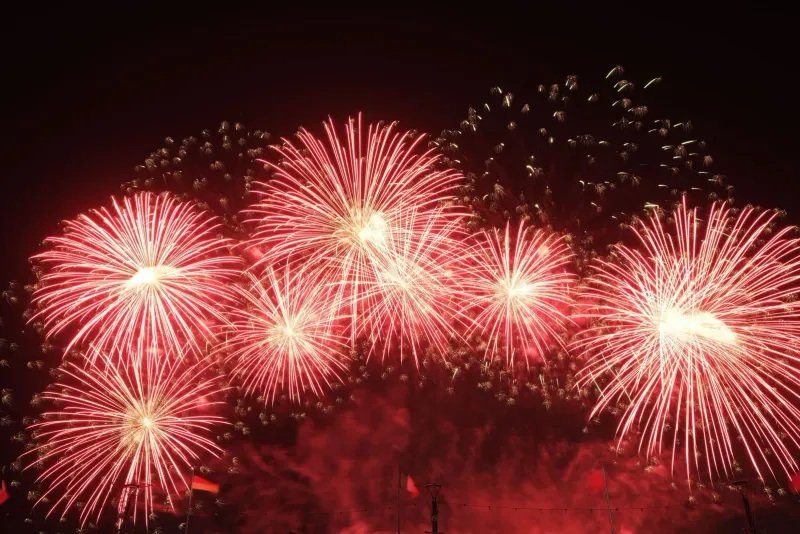 Dazzling fireworks bursting in the night sky above a beach resort during New Year's Eve