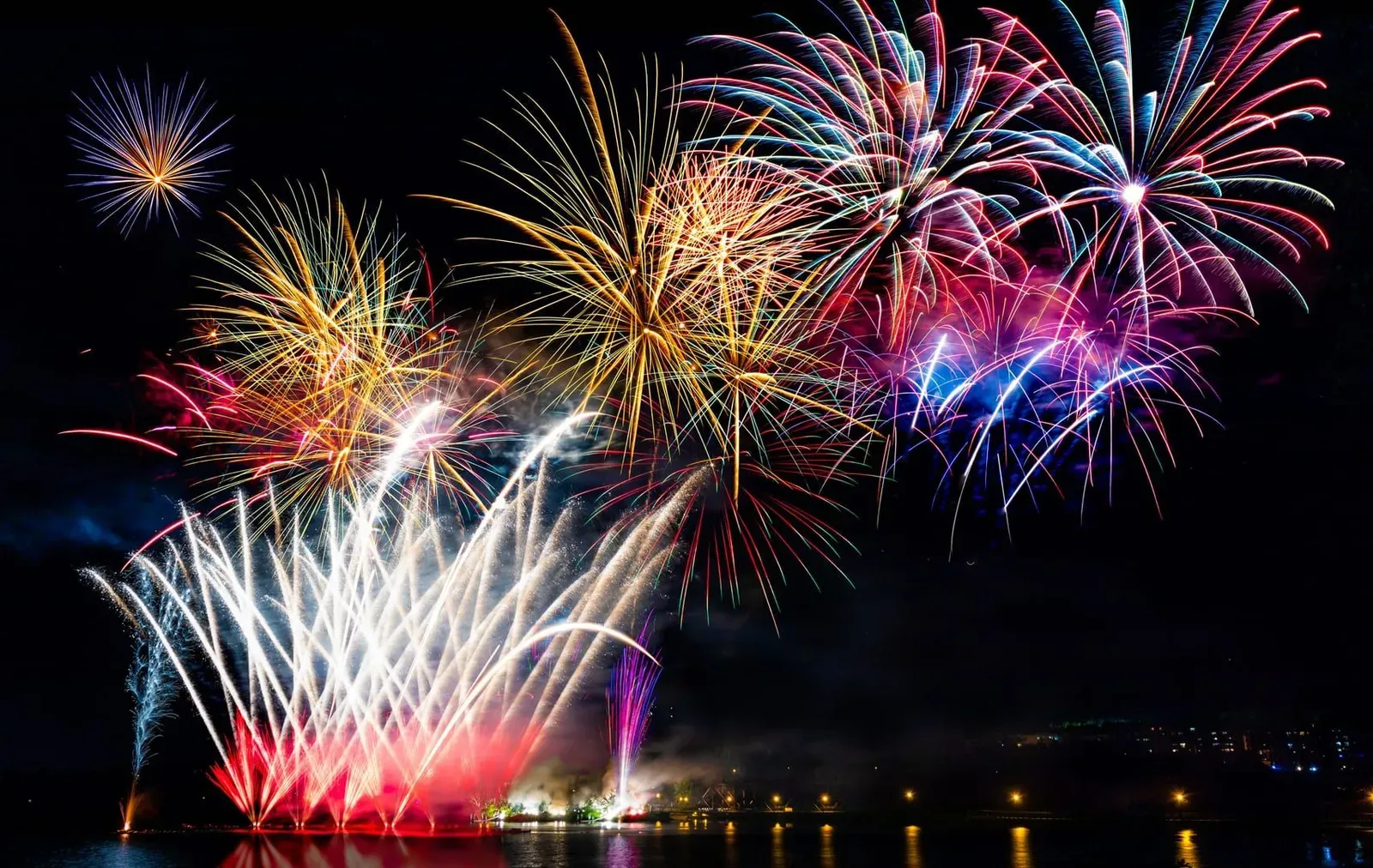 Fireworks reflected over calm water at a tranquil bay near Koh Samui during the festive season