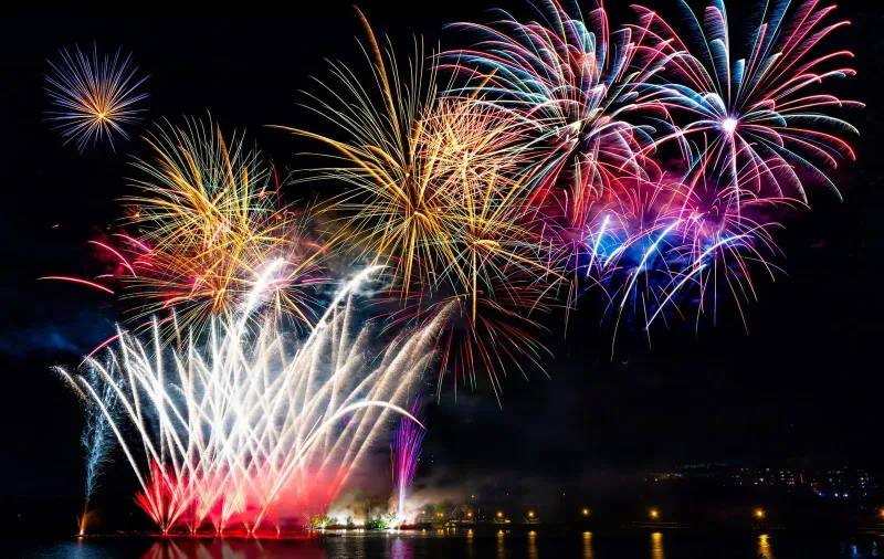 Fuochi d'artificio riflessi sull'acqua calma di una baia tranquilla vicino a Koh Samui durante le feste