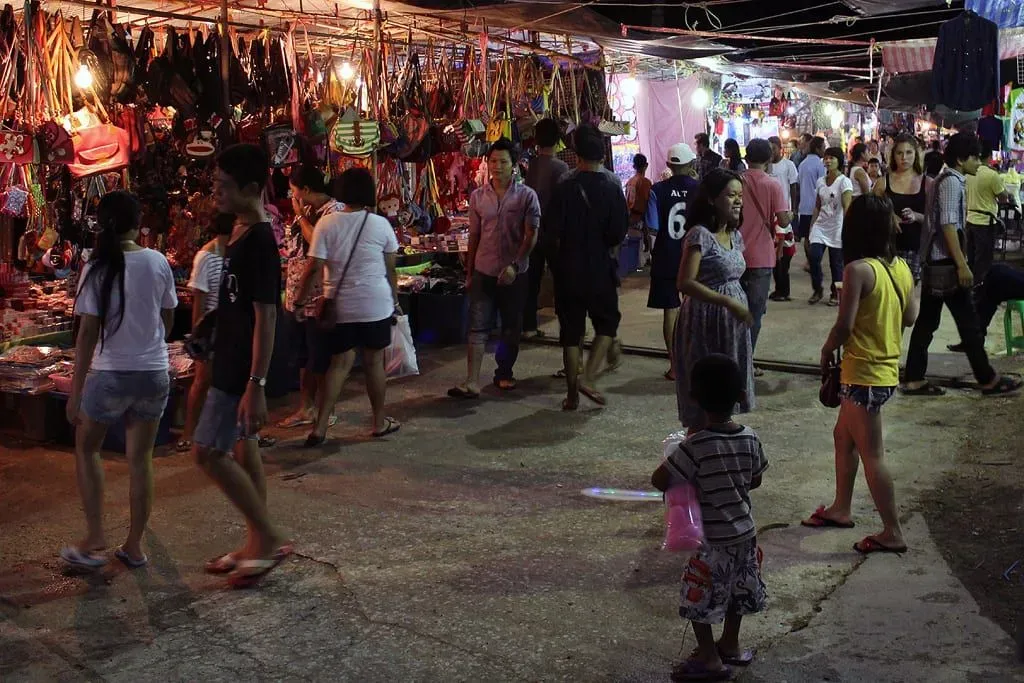 Lantern-lit stalls and shoppers at a Koh Samui night market with food vendors along the street