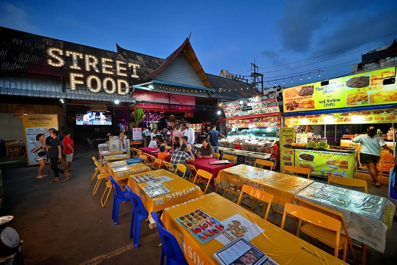 Grilled seafood and street food stalls lit up at a Koh Samui night market in the evening