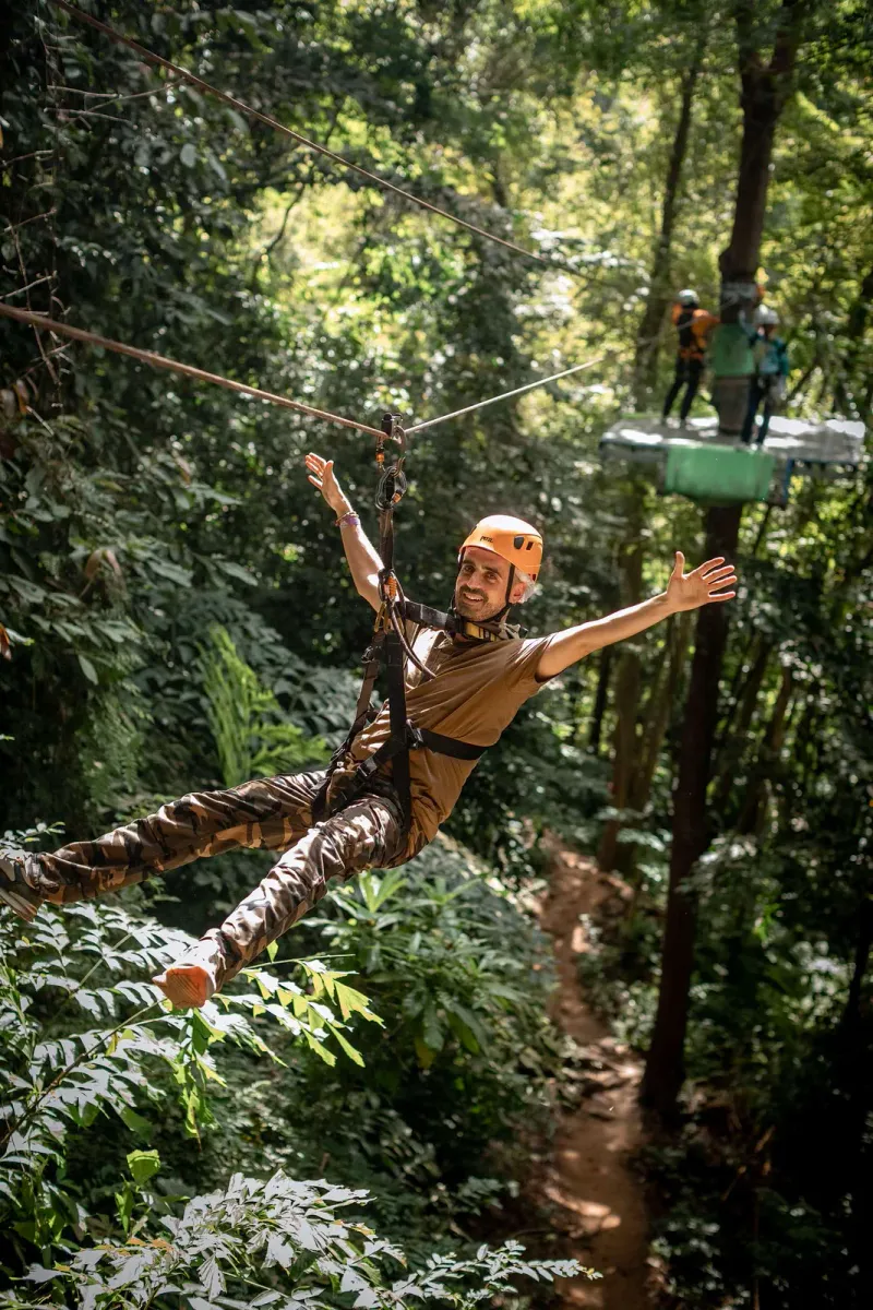 Visitor gliding on a zipline through a rainforest canopy near Koh Samui