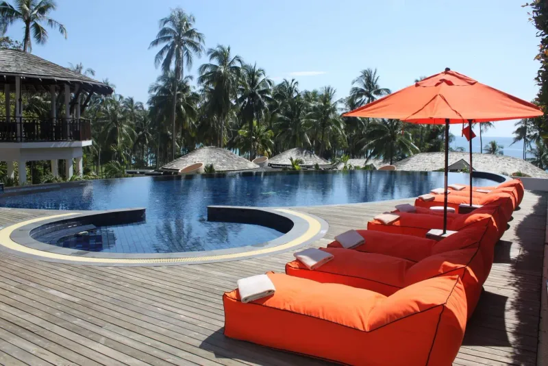 Orange sun loungers beside a resort pool at an affordable Koh Samui resort