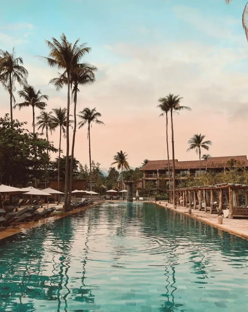 Tropical resort pool at sunset representing a Koh Samui beachfront hotel stay