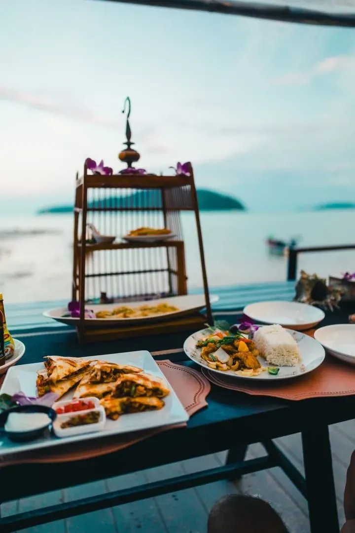 Beachside table set with Thai dishes overlooking the sea, typical of Koh Samui's sunset fine-dining tables