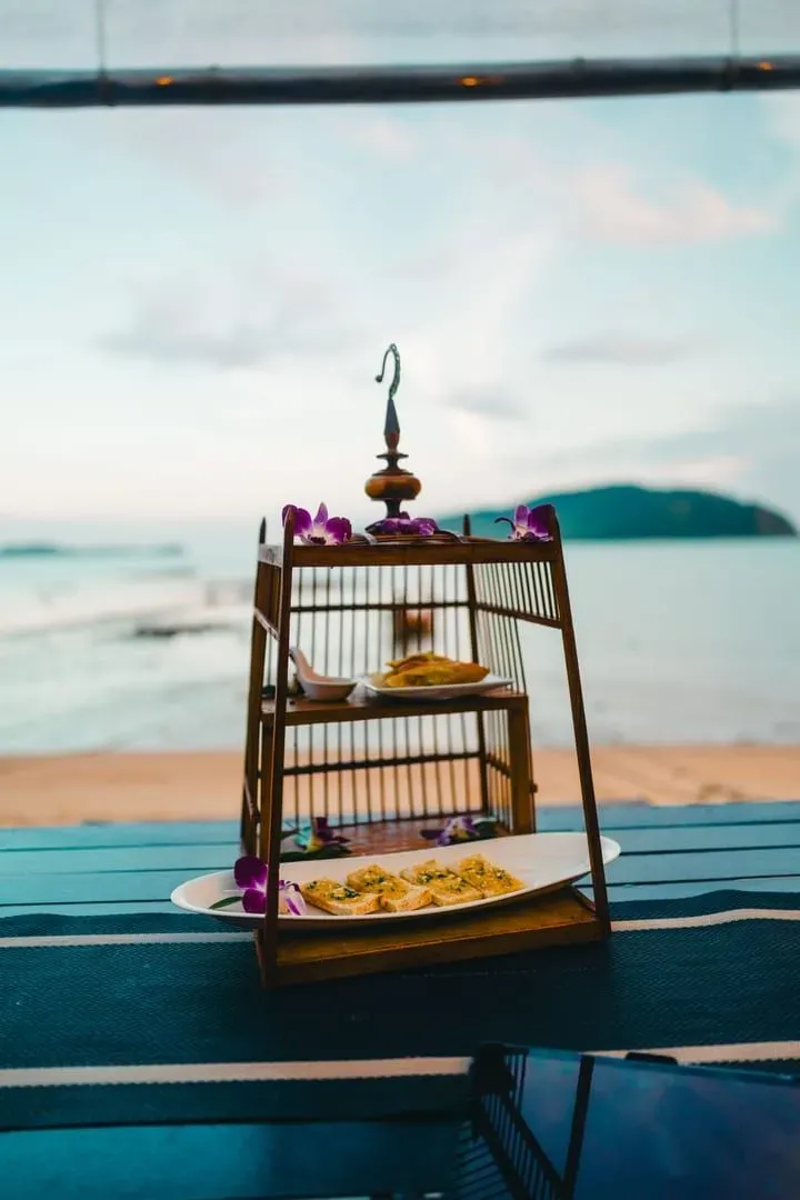 Beachfront table decorated with flowers overlooking the sea at a Koh Samui fine-dining resort