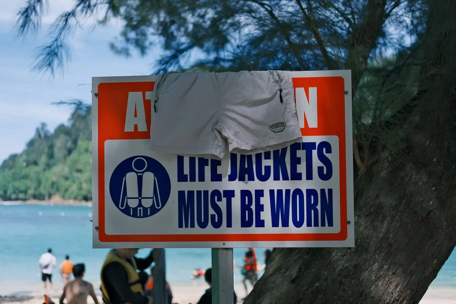 Beach safety sign about life jackets near the shore, a reminder to check local warnings before swimming in Koh Samui