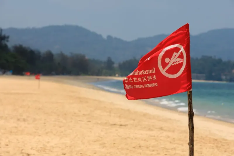 Red swim-prohibition flag on a Thai beach warning against dangerous conditions