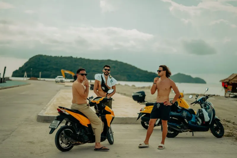 Tourists leaning on rented scooters by the beach on a Koh Samui holiday