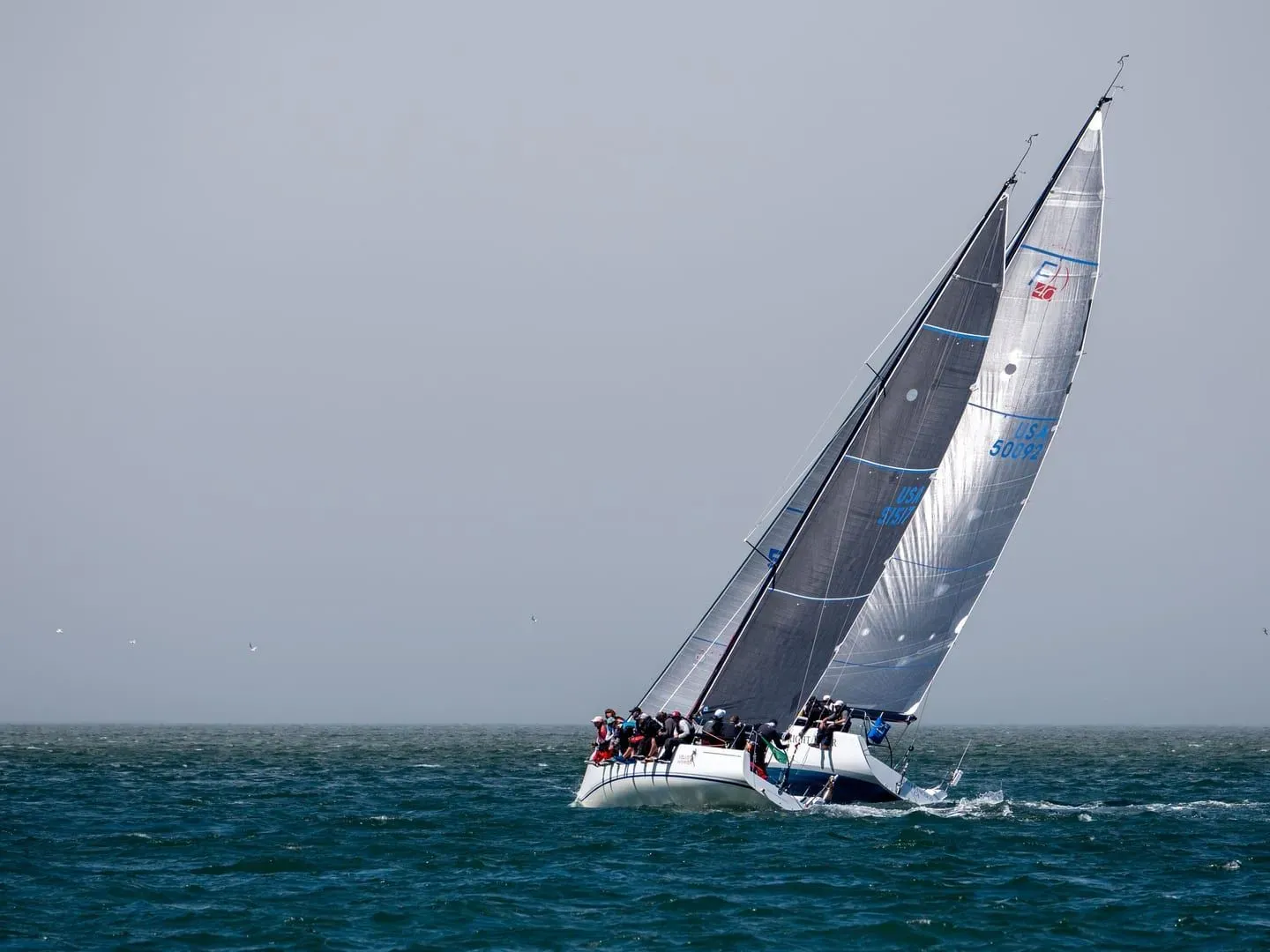 Racing sailing yacht heeled over under full sail on open Gulf of Thailand water off Koh Samui