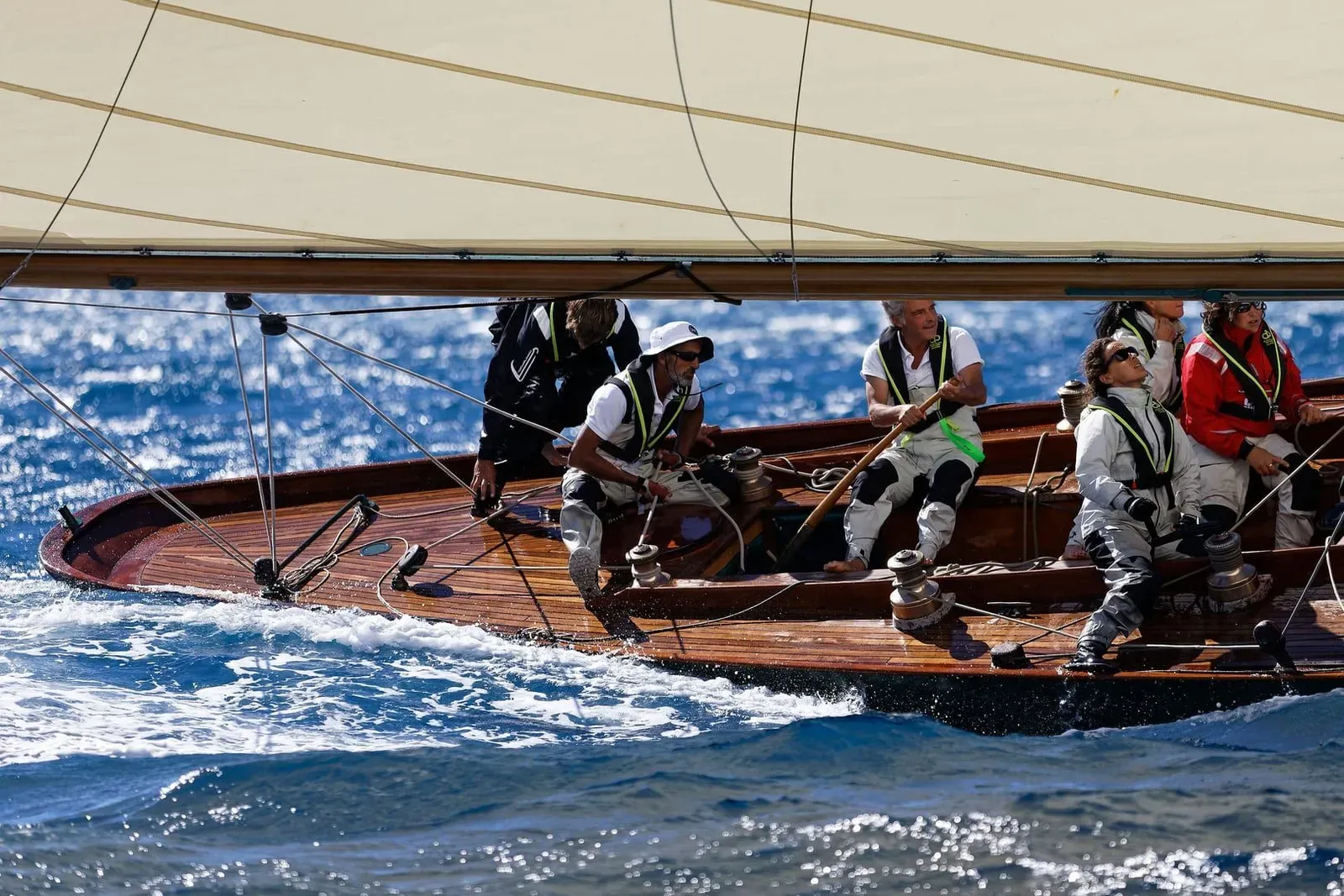 Sailing crew working the deck of a keelboat mid-race, similar to teams competing in the Samui Regatta off Koh Samui