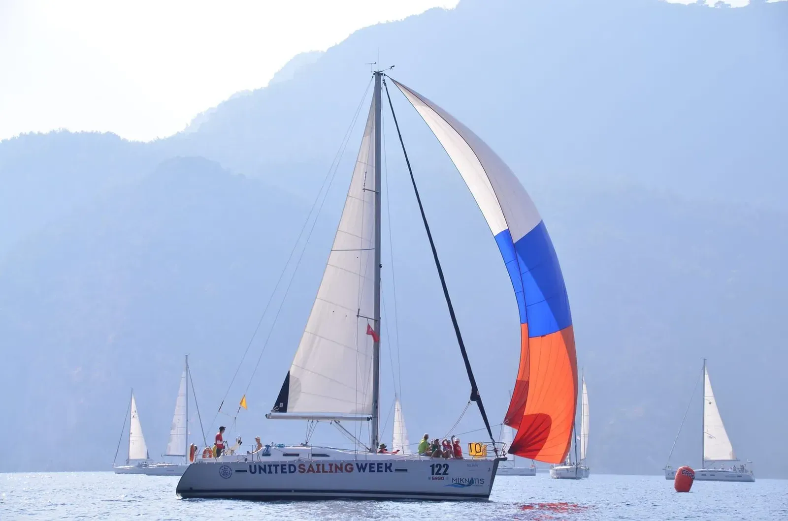 Sailboats racing under a partly cloudy sky typical of Koh Samui's late May weather during regatta week