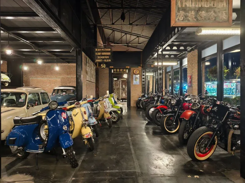 Vintage motorcycles and scooters on display in a Thailand-style garage