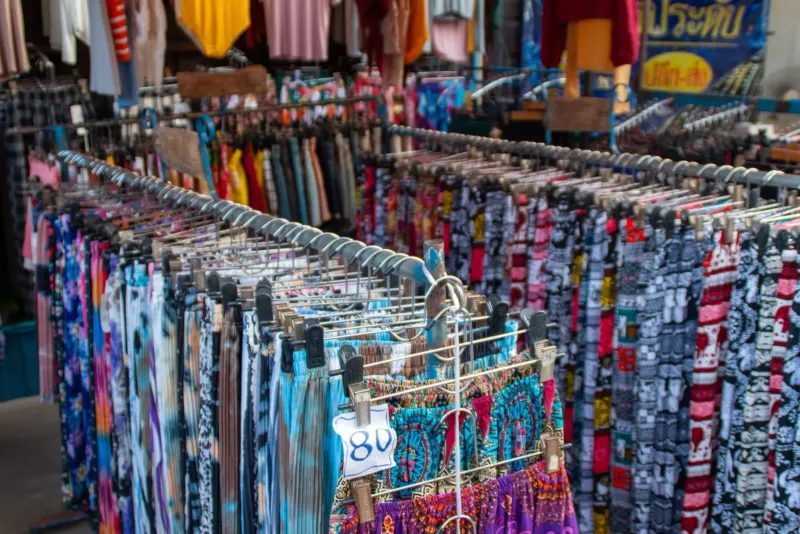 Rack of clothing on display at an outdoor Koh Samui market stand