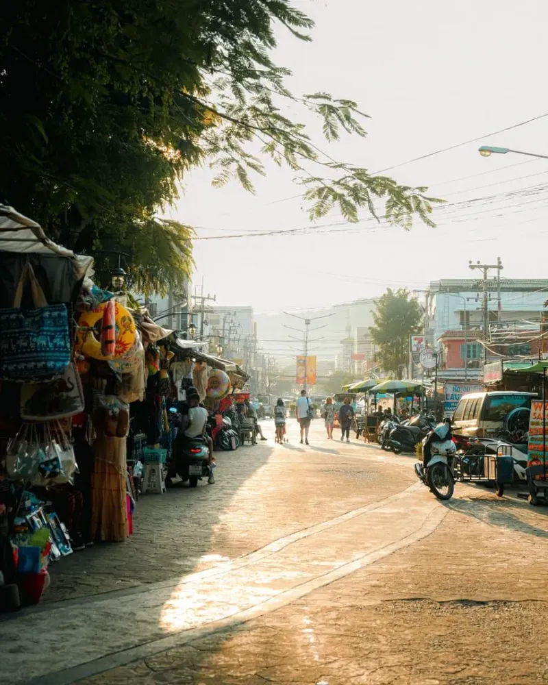 Bustling Thai street market at sunset with food vendors typical of a Koh Samui backpacker evening