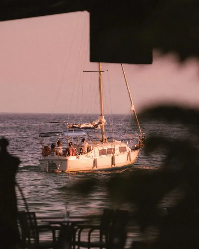 Guests riding a sailboat cruising the ocean at sunset near Koh Samui