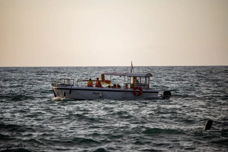 Small charter boat on calm water off Koh Samui at golden hour