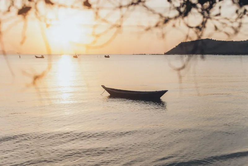 Boat on the water at sunset representing a private charter off Koh Samui