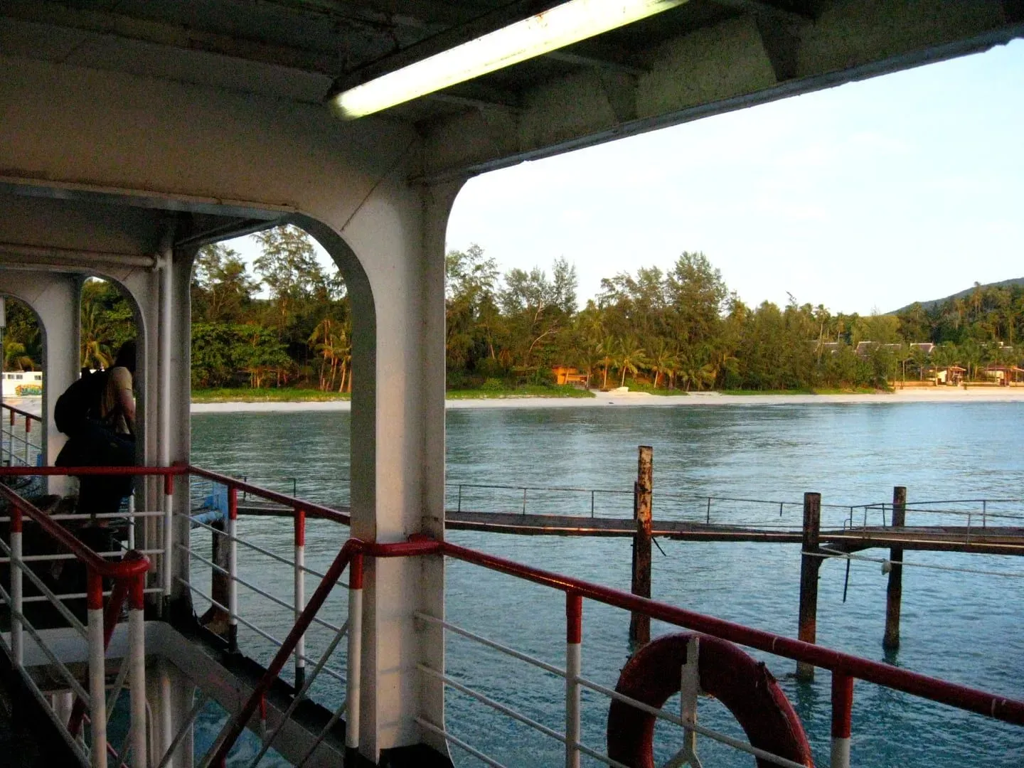 Ferries docked at Nathon Pier on Koh Samui's west coast with hills behind at day's end