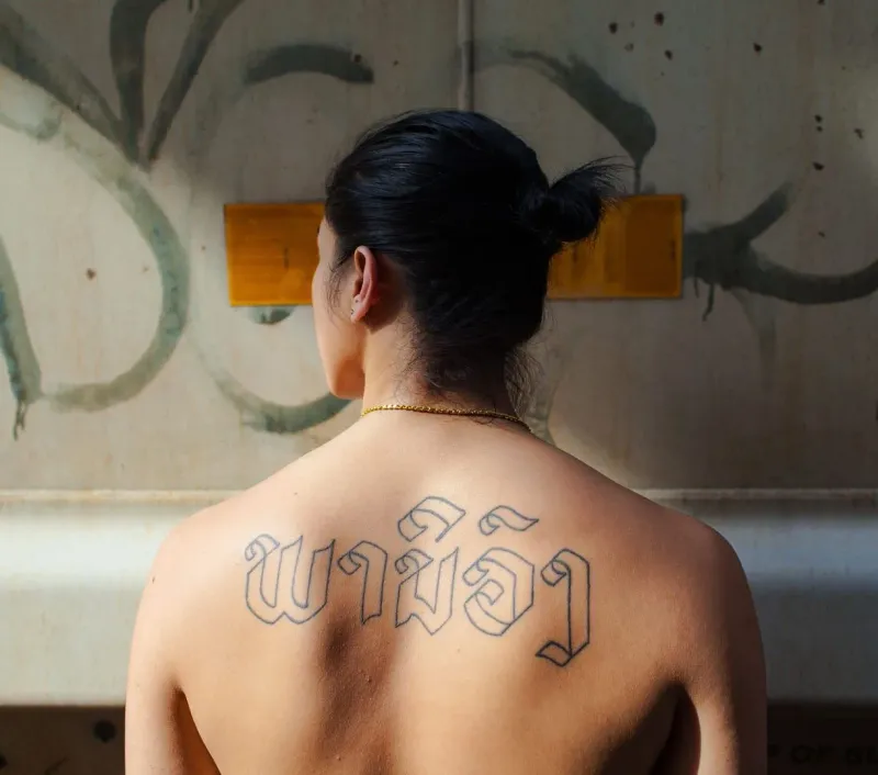 Person displays a large healed back tattoo, an example of custom studio tattoo work