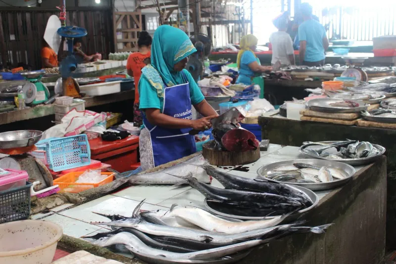 Local vendor at a Koh Samui wet market, a stop often included on private driver day hire tours