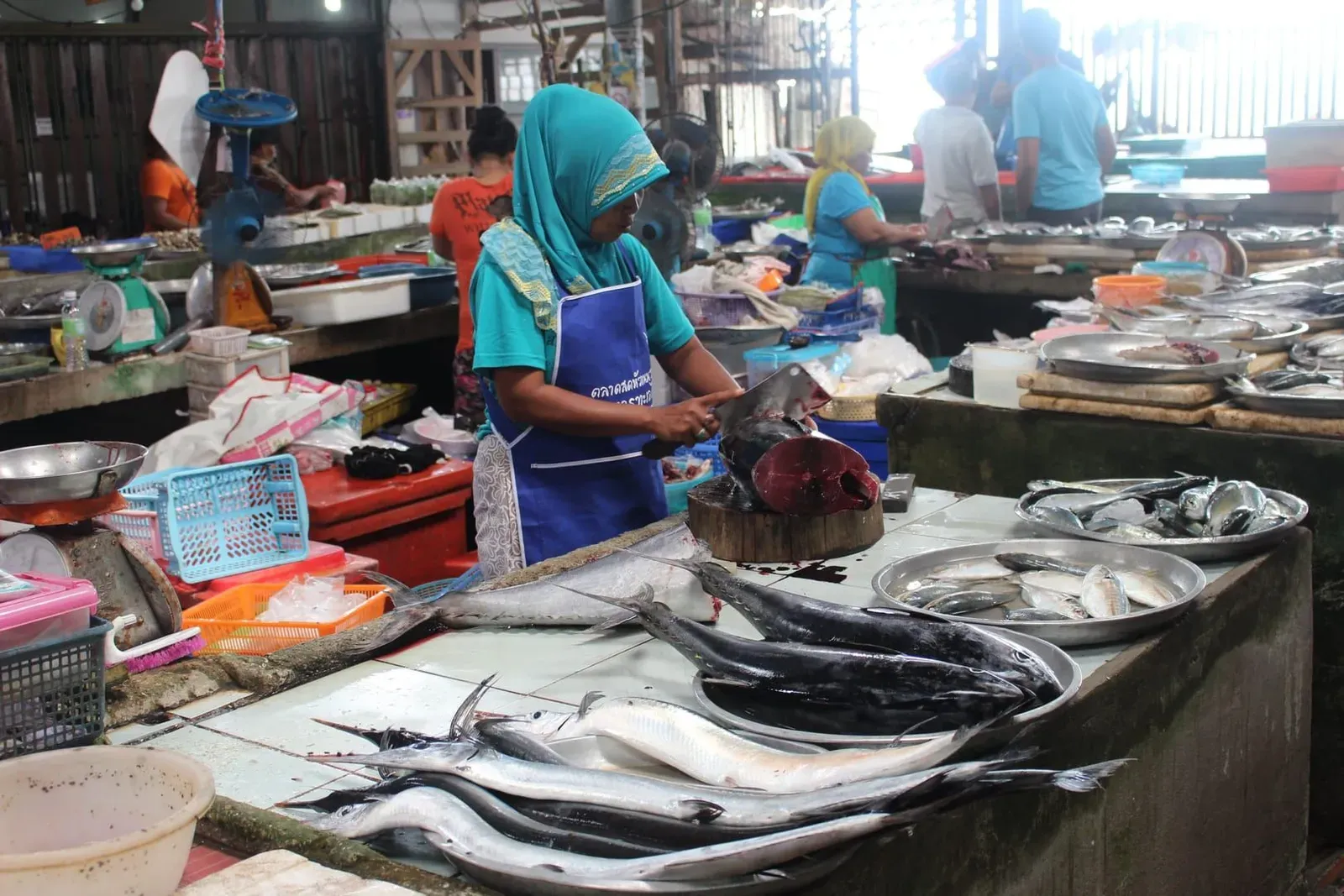 Local vendor preparing fresh fish at a wet market on Koh Samui island