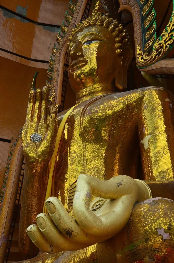 Golden Buddha statue in a meditation posture inside a Thai wat
