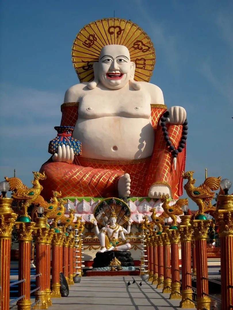 Buddha statue among the lakeside temple buildings of Wat Plai Laem near Bophut, Koh Samui, an example of a mixed Theravada and Mahayana site