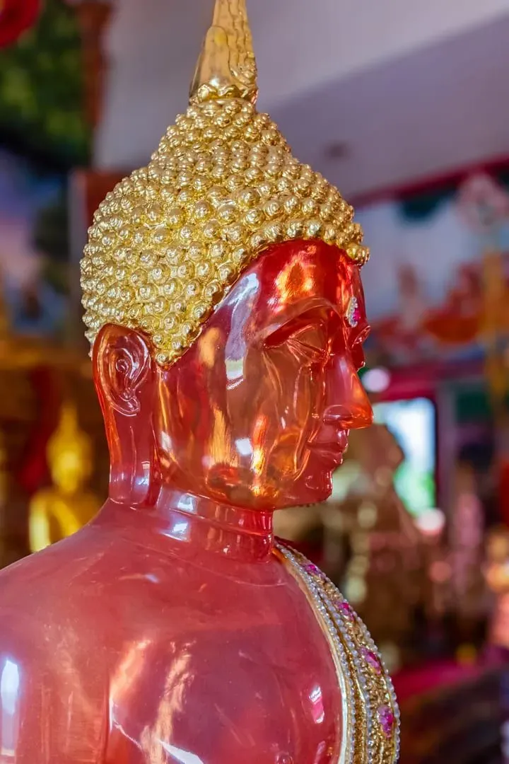 Close-up of a golden Buddha statue showing intricate Thai temple carving detail