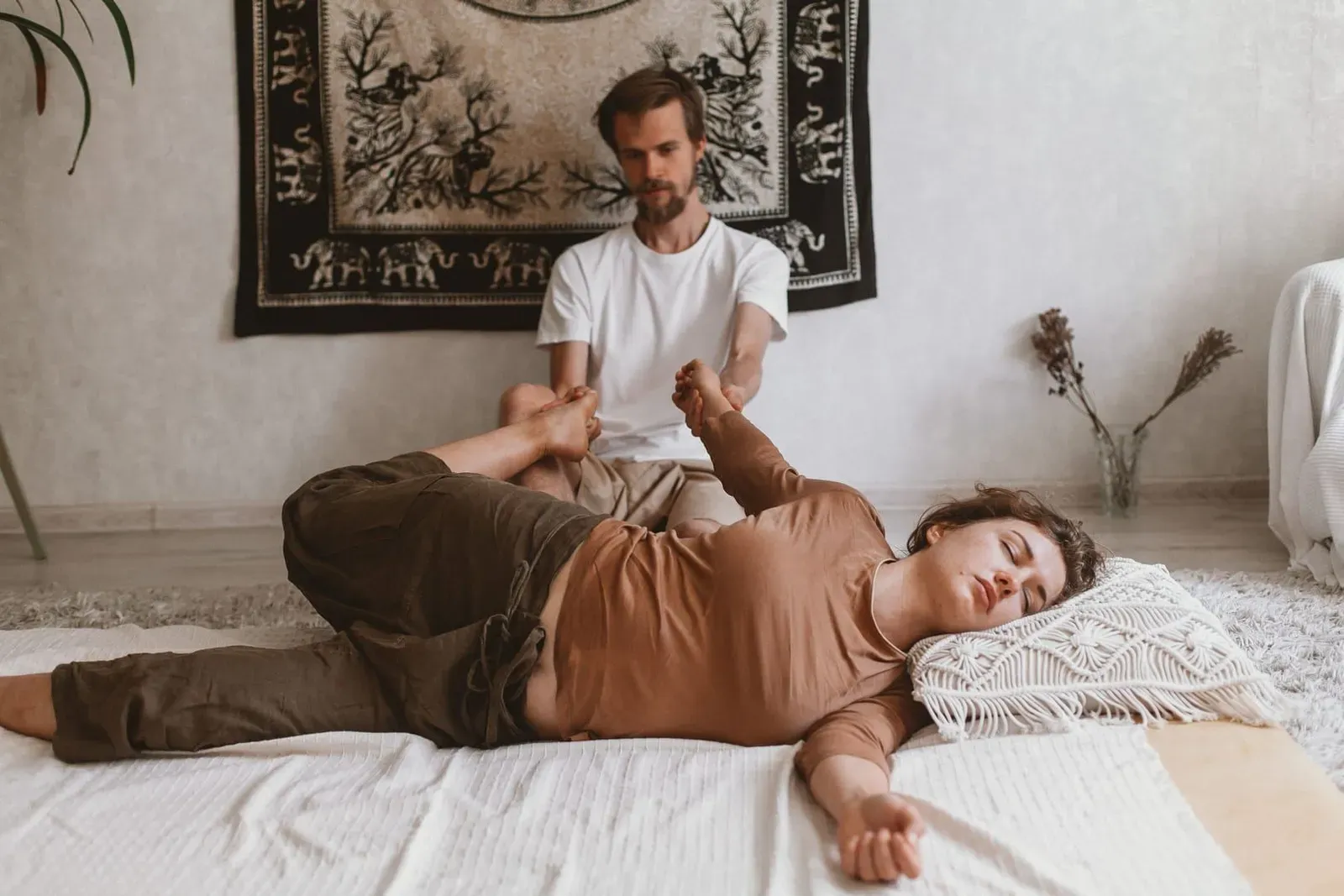 Woman receiving an assisted stretch during traditional Thai massage on Koh Samui