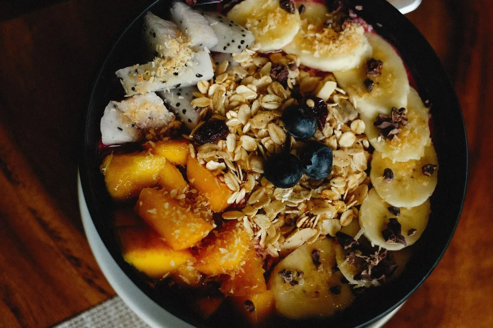 Vibrant raw vegan breakfast bowl with fresh fruit, oats and granola in Koh Samui