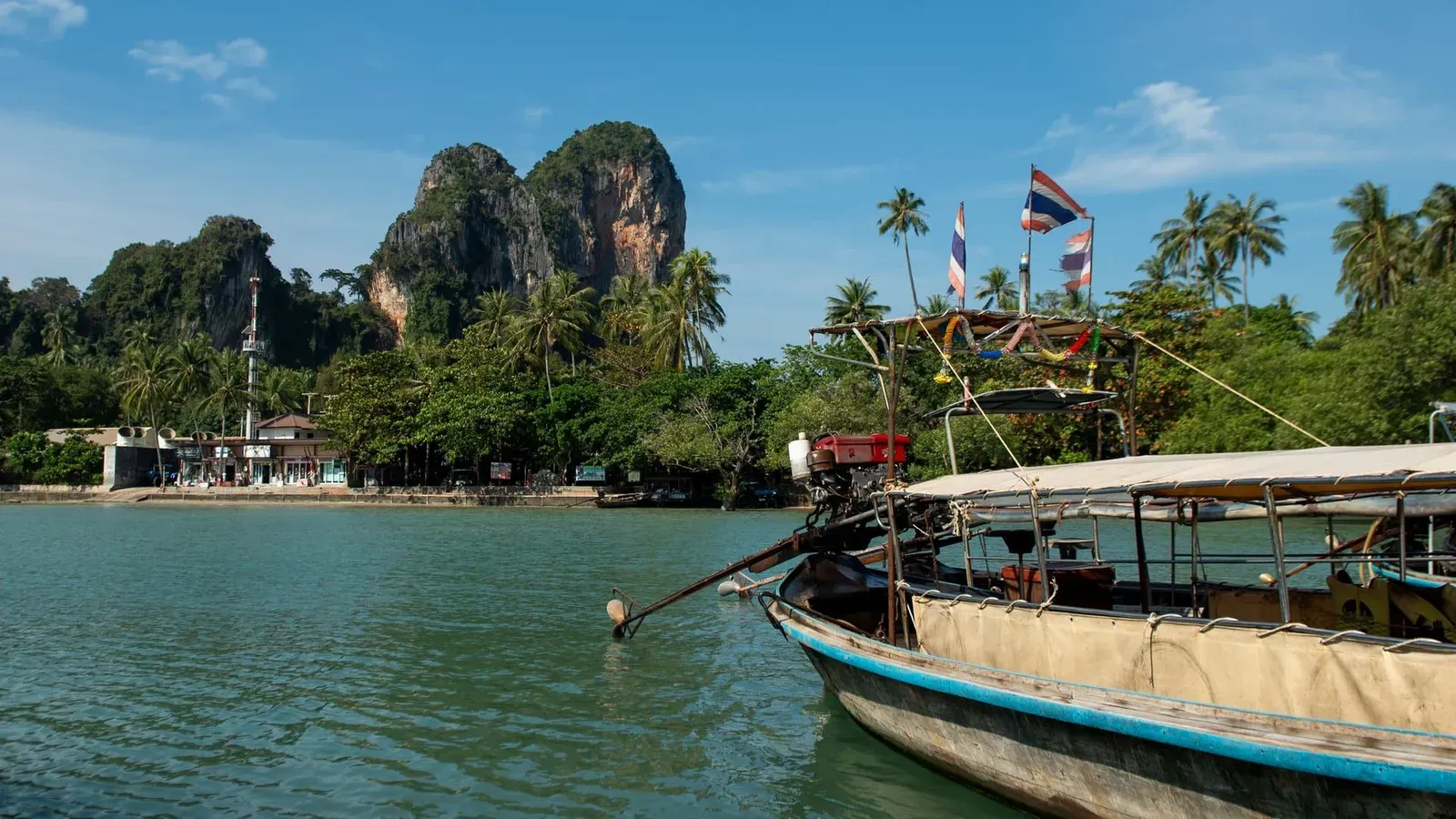 Longtail boat beneath limestone cliffs on the Krabi coast Thailand