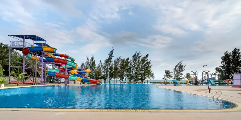 Colorful slide tower next to a swimming pool at a tropical water park