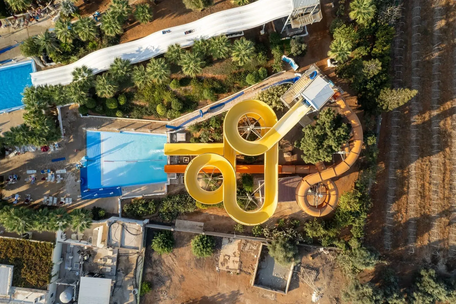 Aerial view of a tropical water park's pools and slide towers, similar to the layout on Koh Samui's north coast