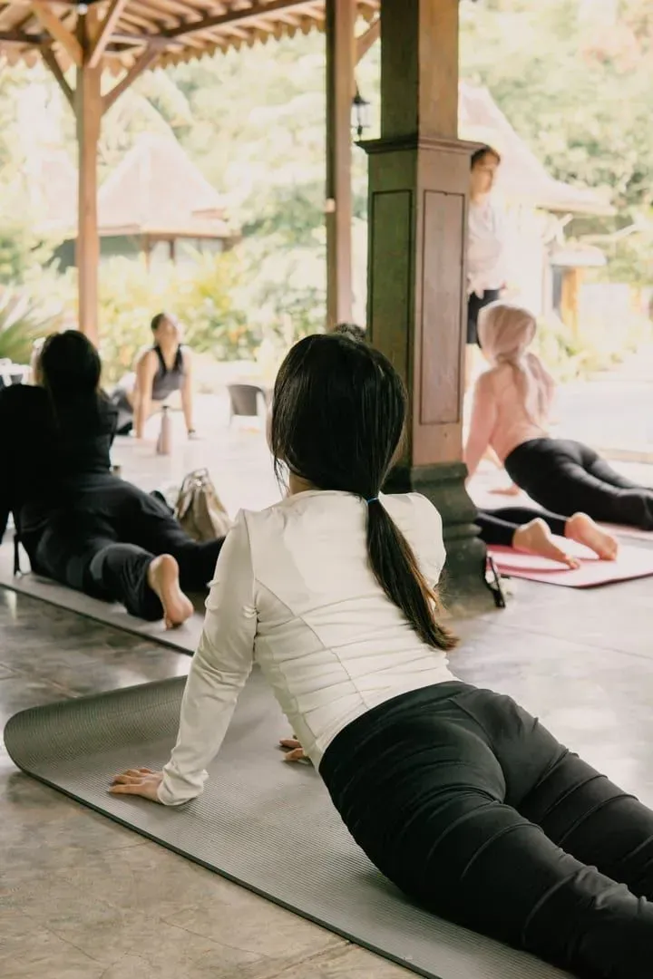 Adults holding standing yoga poses together outdoors in soft morning light