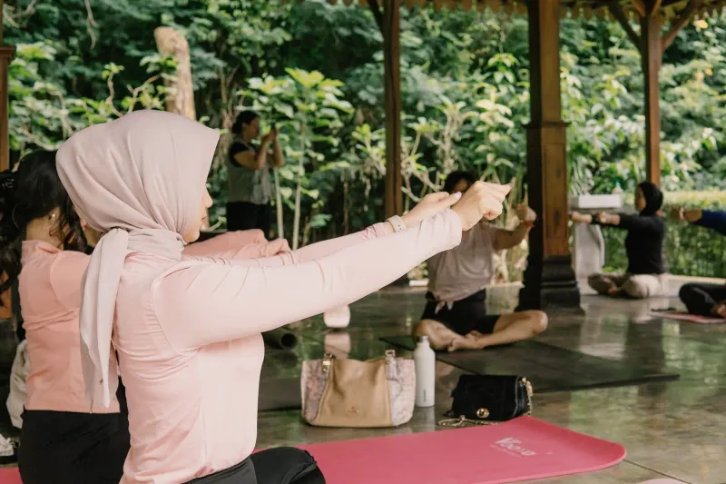 Small group of women practicing yoga together in an open pavilion